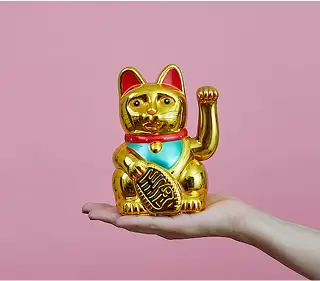 手の平の上に金色の招き猫をのせた写真
