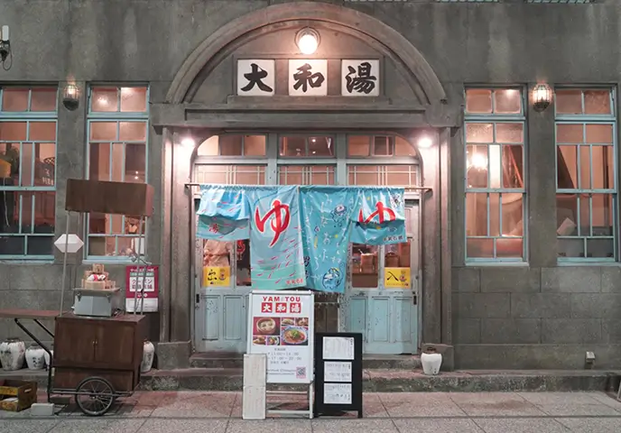「大和湯」という看板と、「ゆ」の字の暖簾がかかった、銭湯のような外観の写真